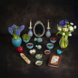 A traditional Persian Haft-Seen table setting for Nowruz with symbolic items and flowers